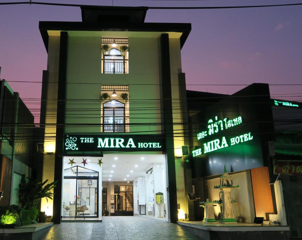 The Mira Hotel Chiang Rai في شيانج راي: مبنى أخضر توجد أمامه لافتات نيون
