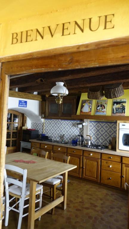 una cucina con un tavolo e un cartello con la scritta Bernanke di Un grand gîte *** à Lavoûte-Chilhac a Lavoûte-Chilhac