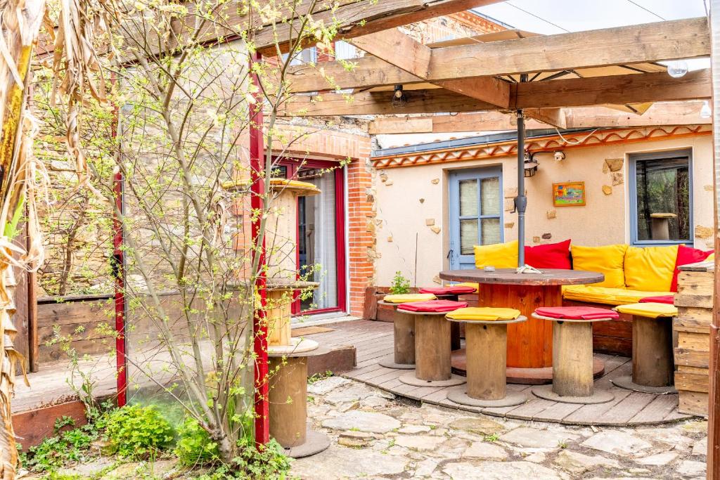 a patio with a table and chairs and a bench at Maison familiale sud Nantes in Bouguenais