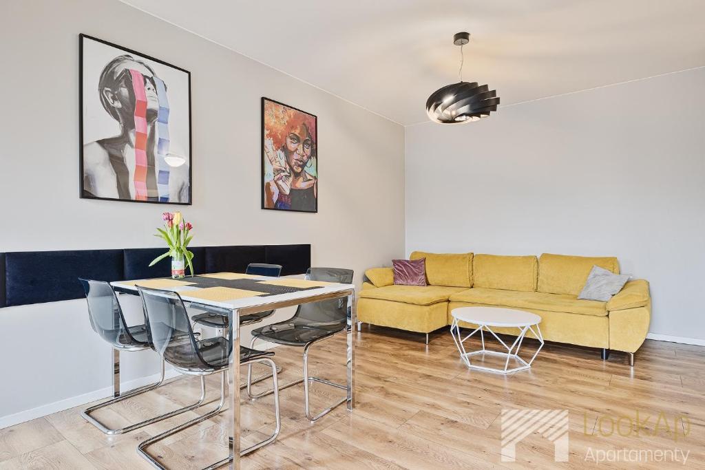 a living room with a yellow couch and a table at Central Park by LookAp in Łódź