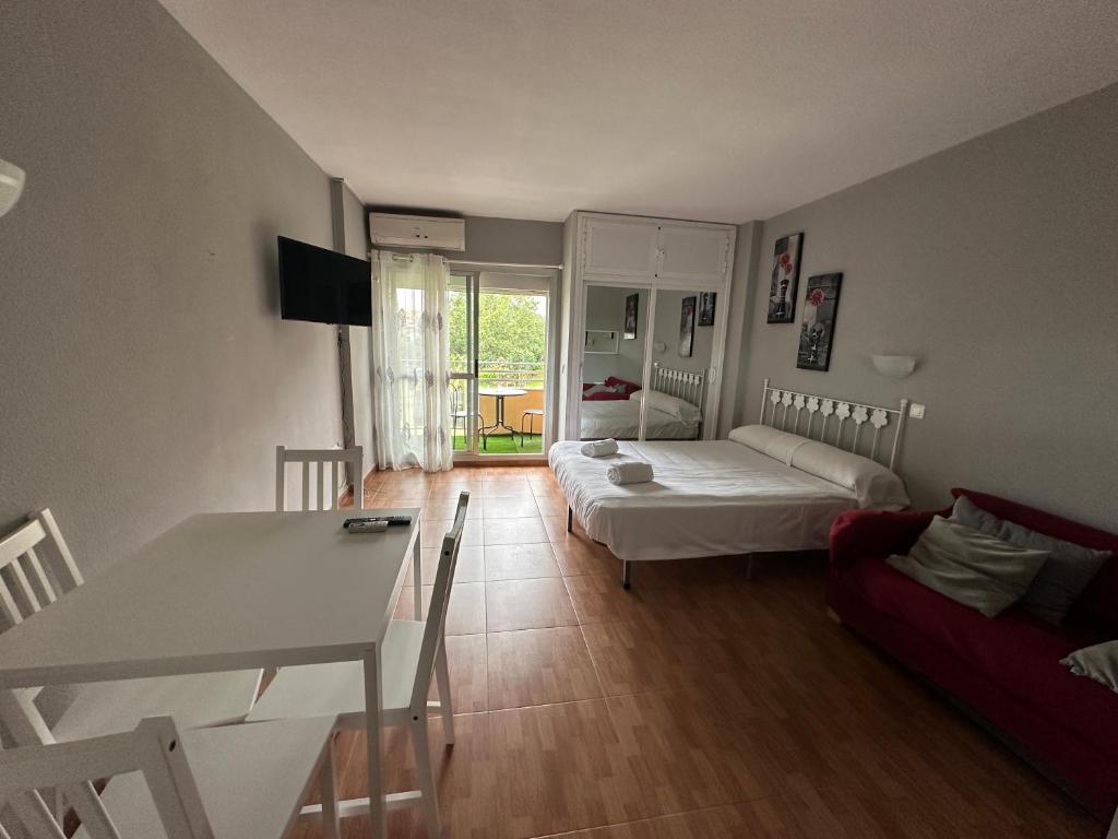 Sala de estar con cama y mesa en Sunstay LOFT MINERVA, en Benalmádena