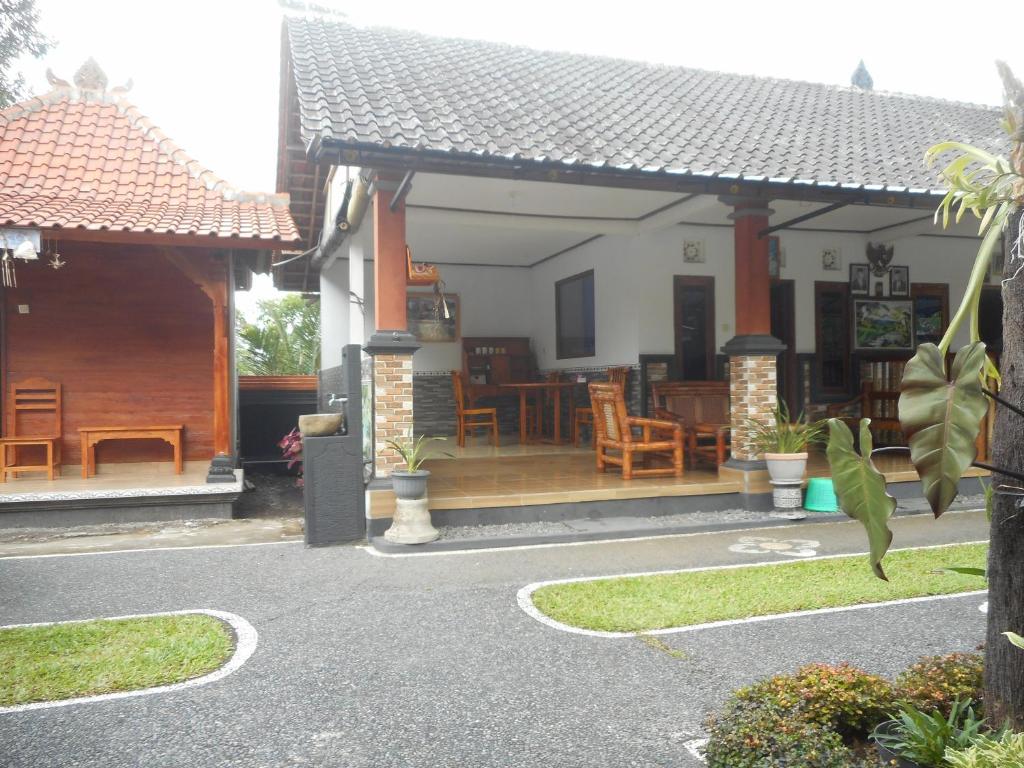 a house with a porch and a deck with chairs at Kadek Homestay in Besakih
