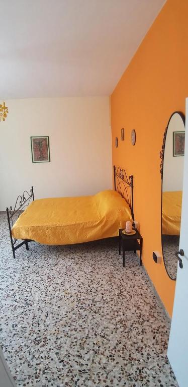 un letto in una camera con parete arancione di B&B SERENDIPITY a Castelbelforte