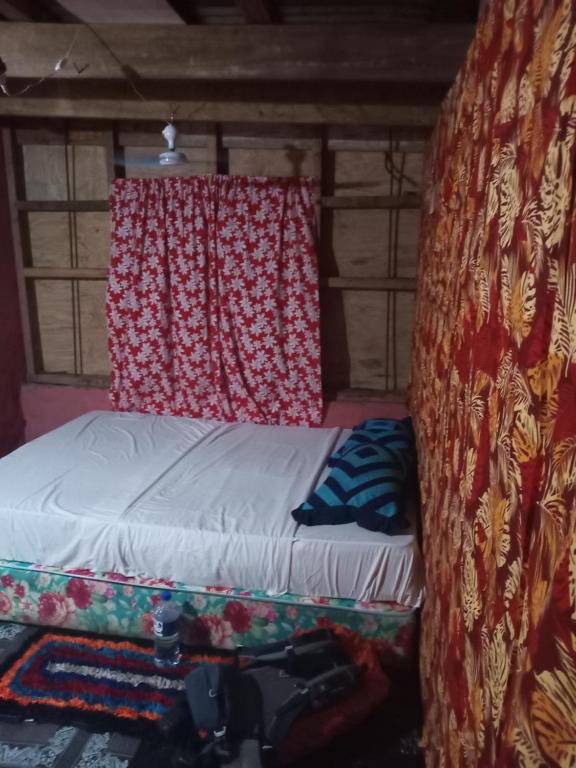 Cama en habitación con cortina y cámara en Lusis Homestay, en Lautoka