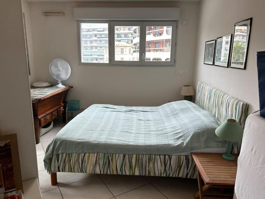 une chambre avec un lit, un bureau et une fenêtre dans l'établissement Appartement plein centre, à Antibes