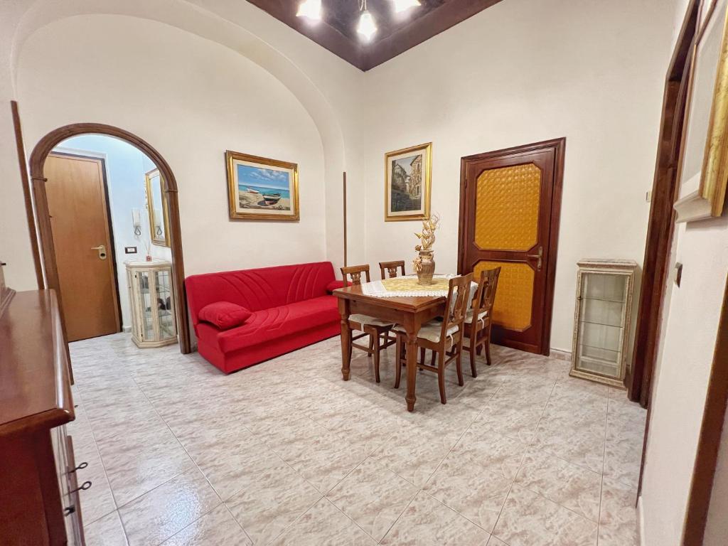Una sala de estar con un sofá rojo y una mesa. en Casa Leandra, en Civitavecchia