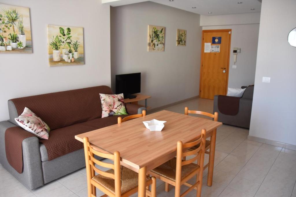a living room with a table and a couch at Panorama Beach House in Mascali
