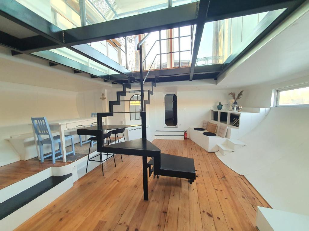Ce loft comprend une table et des chaises. dans l'établissement EXIGEHOME - La Perle Jaune du Port Marly - 25 min de Paris, à Le Port-Marly