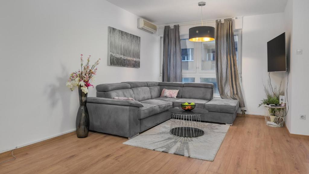 Deluxe City AS Apartment - FREE PARKING في زغرب: غرفة معيشة مع أريكة وطاولة