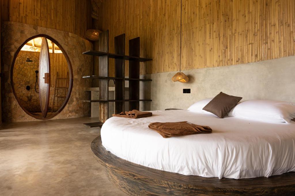 a bedroom with a large bed with a wooden wall at Villa con Piscina Vista Mare - Lussuosa - Villa Chiara, Anima Eco Lodge in Selong Belanak