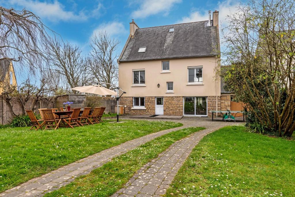 a house with a table and chairs in the yard at Maison 15pers 300m de la plage in Crozon