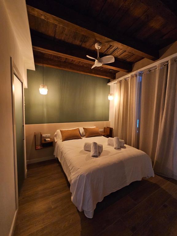 una camera con letto bianco e ventilatore a soffitto di Siete Lunas a Cordoba
