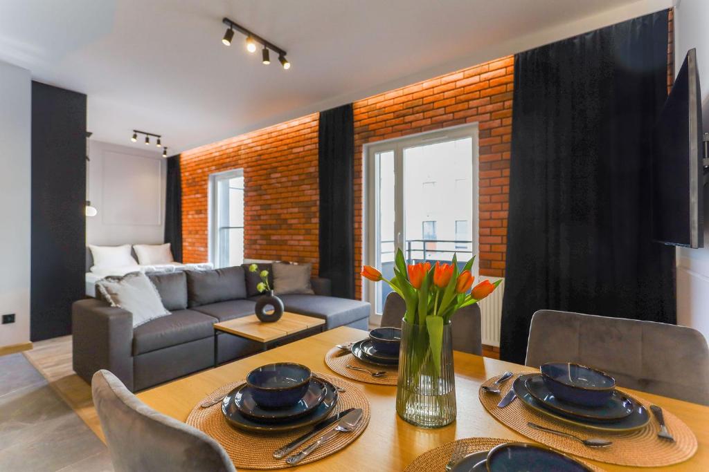 a living room with a table and a couch at Red Old Town Apartament in Elblag