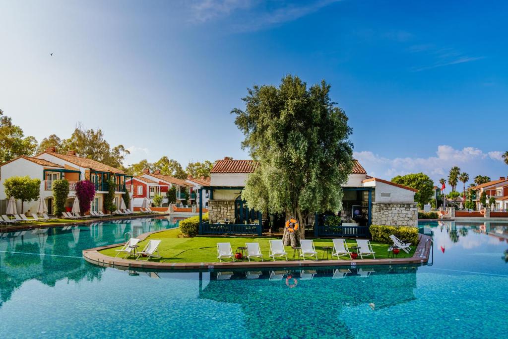 ein Resort mit einem Pool mit Stühlen und einem Baum in der Unterkunft IC Hotels Santai Family Resort - Kids Concept in Belek