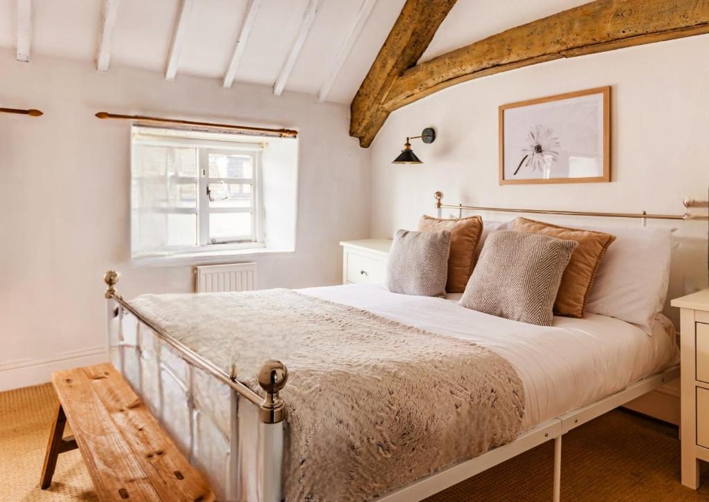 - une chambre avec un grand lit et une fenêtre dans l'établissement Inglenook Cottage, The Cotswolds, à Winchcombe