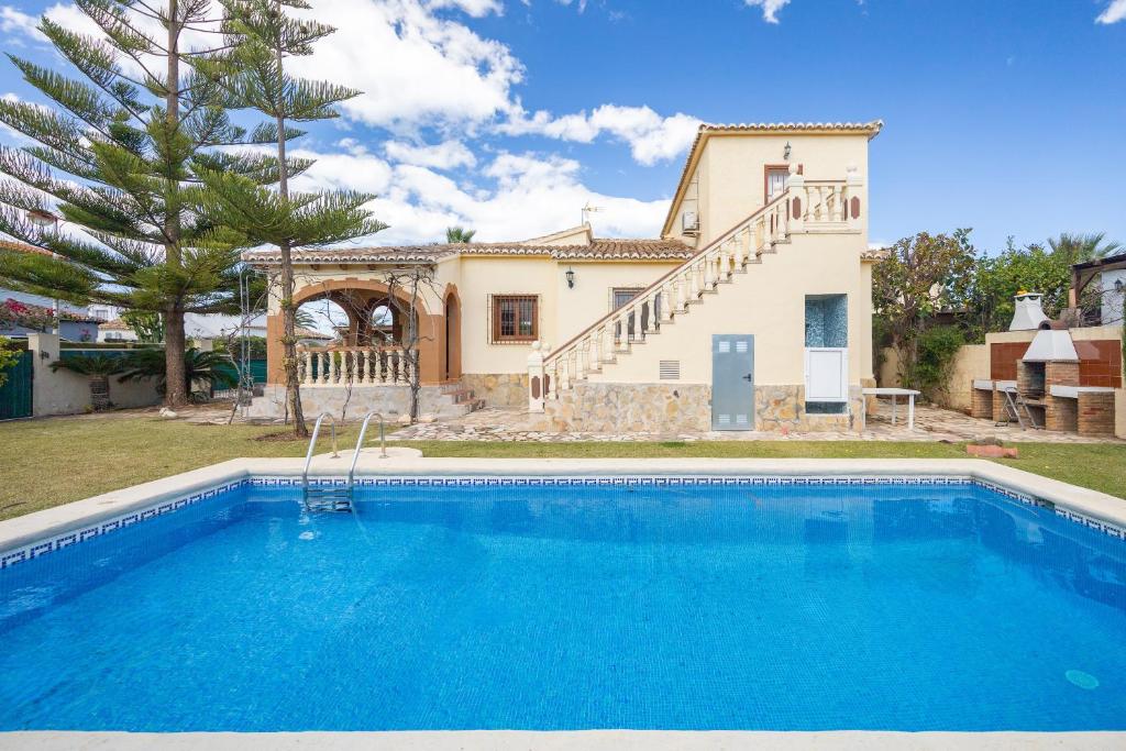 une villa avec une piscine en face d'une maison dans l'établissement Villa Vilches, à Els Poblets