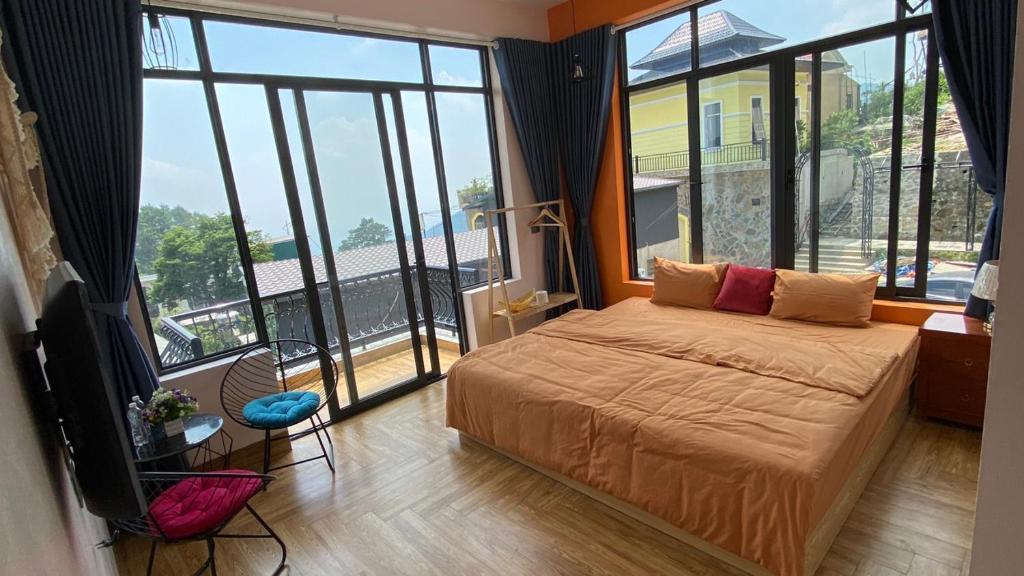 een slaapkamer met een bed en een groot raam bij Thung Lũng Mây Tam Đảo in Vĩnh Phúc