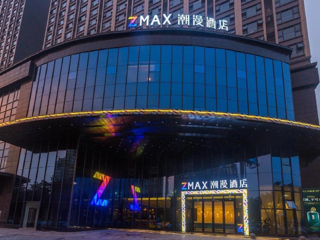 a large glass building with a sign on it at Zmax Qingyuan Guangqing Railway Station in Qingyuan