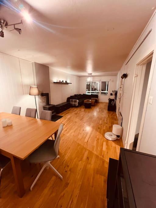 a living room with a wooden table and a dining room at Komplett leilighet ved Tiller in Trondheim