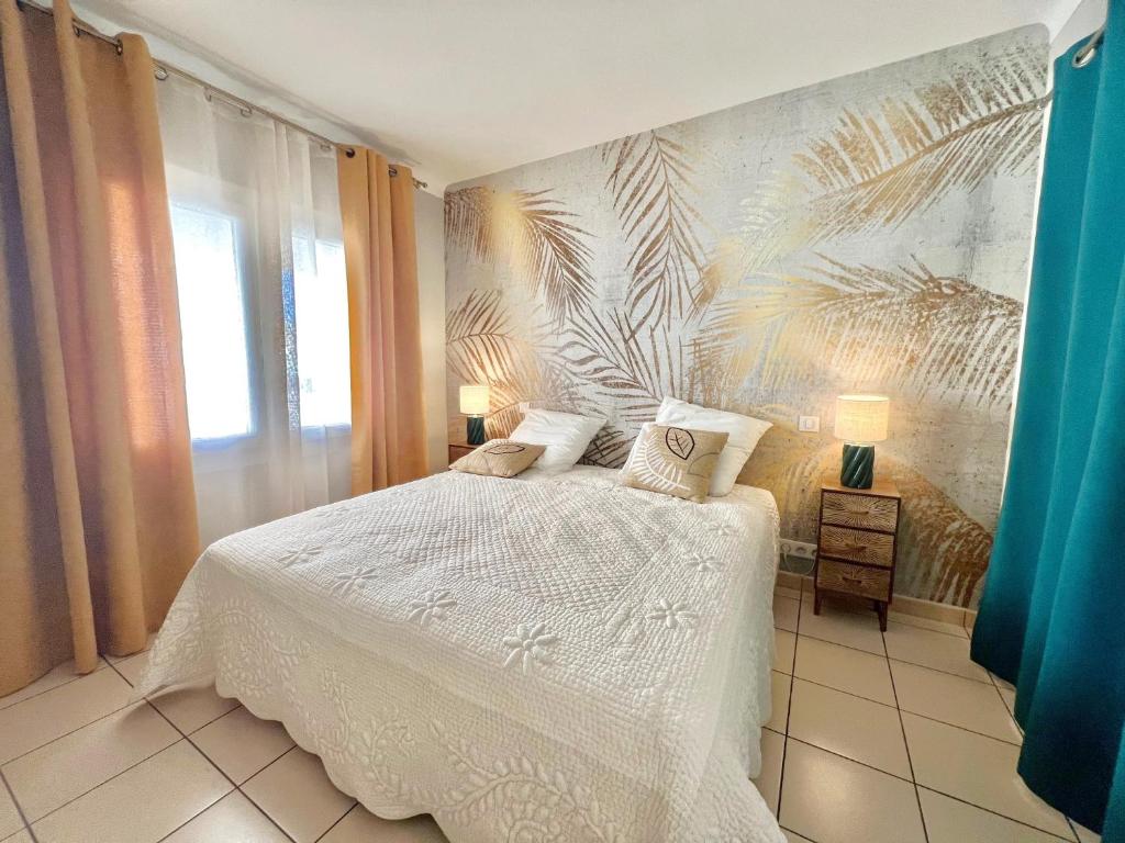 - une chambre avec un lit blanc et un papier peint tropical dans l'établissement Savannah appartement proche Carlton, by Welcome to Cannes, à Cannes