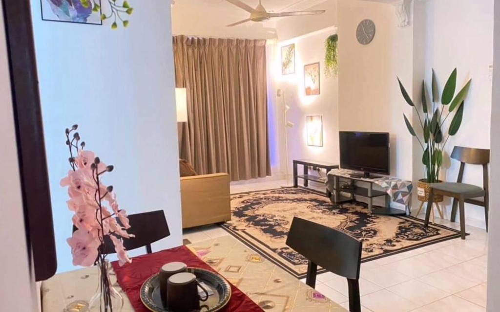 un salon avec une table à manger et une télévision dans l'établissement HOMESTAY ANGGUN SAFIYYA, à Bayan Lepas