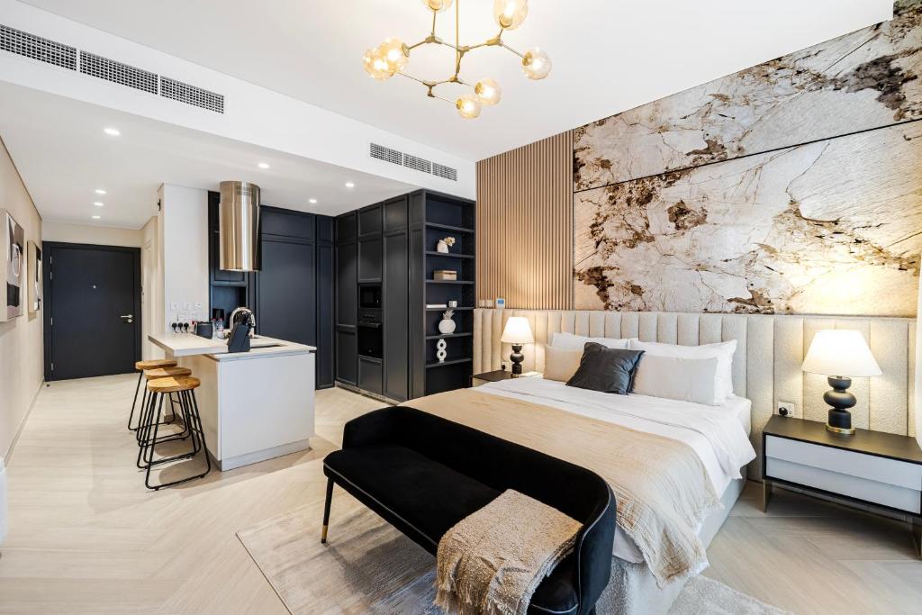 a bedroom with a large bed and a kitchen at Elegant Brand New Studio Wilton Park Residence MBR in Dubai