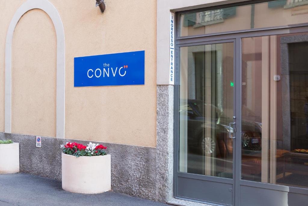 una señal en el lado de un edificio con flores en The Convo Lake Como, en Como