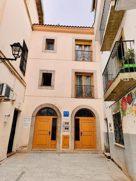 a building with orange doors on a street at APARTAMENTOS TURíSTICOS MONTASOL 1 in Montánchez