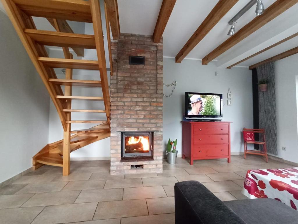 a living room with a fireplace and a staircase at Kostek in Rowy