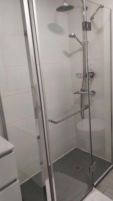 La salle de bains est pourvue d'une douche avec une porte en verre. dans l'établissement Apartamento centrico, à Alicante
