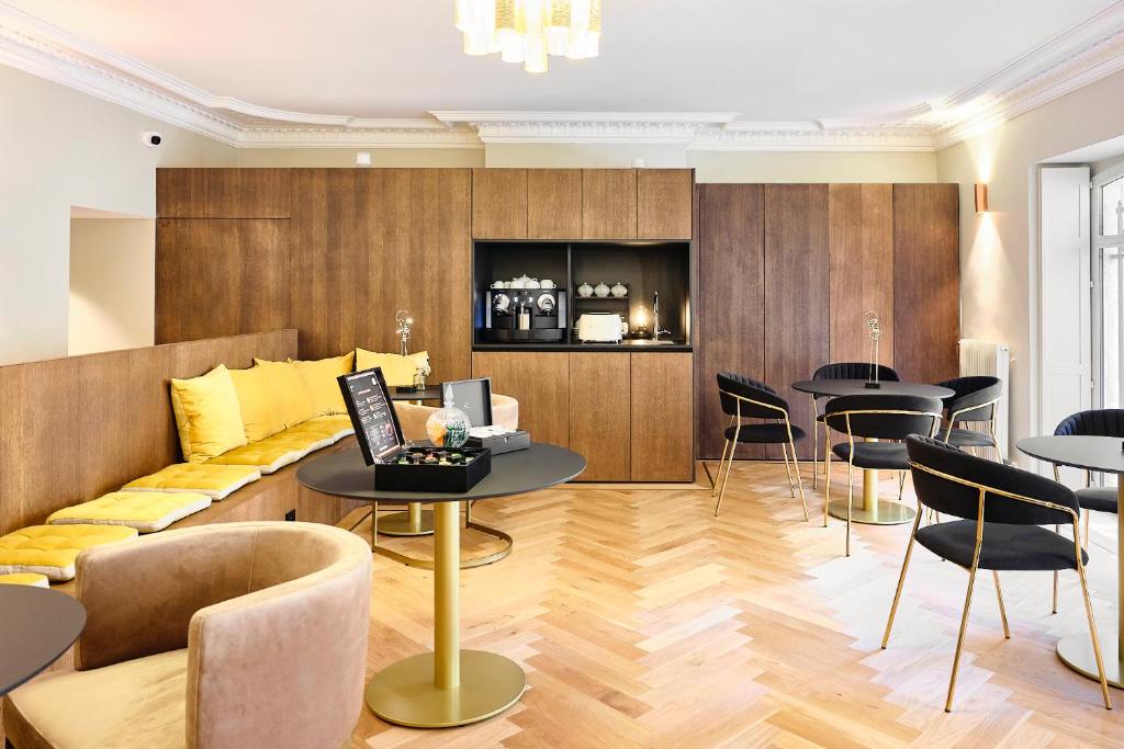 a living room with a couch and tables and chairs at Maison Heym Bordeaux in Bordeaux