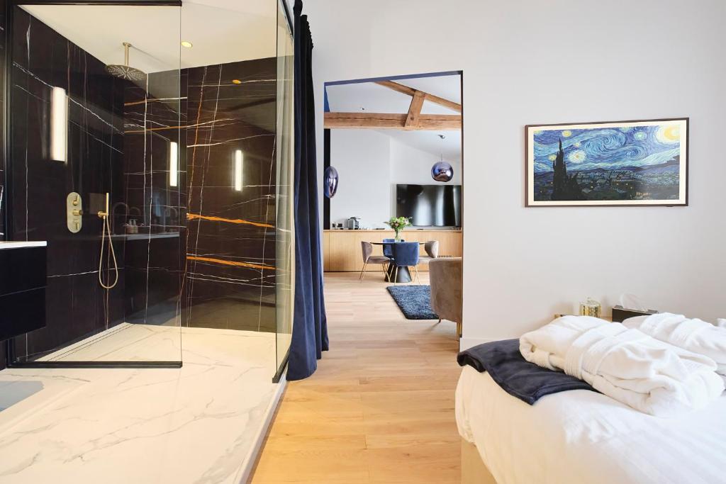a bathroom with a glass shower and a bed at Maison Heym Bordeaux in Bordeaux