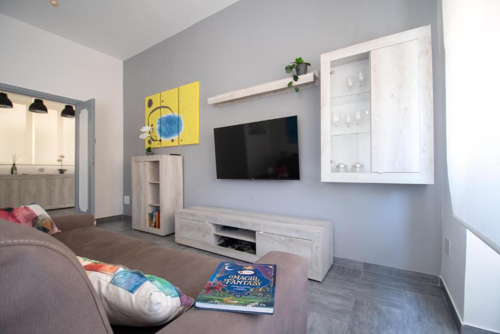 salon z kanapą i telewizorem na ścianie w obiekcie Casa Vacanze Family House posizione centralissima w mieście Civitavecchia
