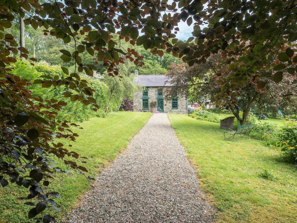 a garden path leading to a house with a building at Rhyd y Brown Farmhouse Llys Y Fran in Pen-ffordd