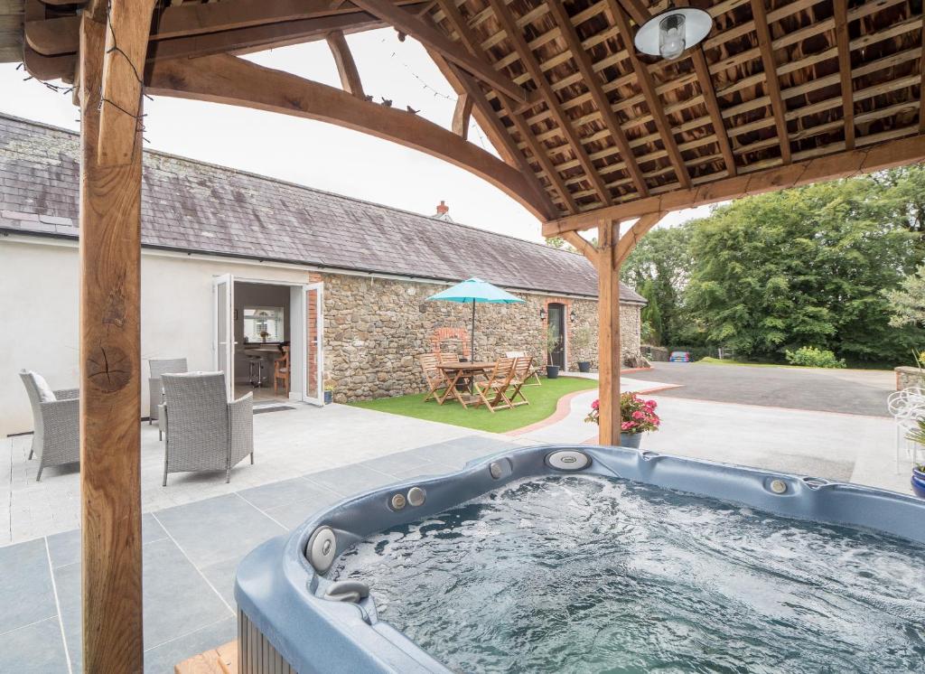 a hot tub in the backyard of a house at White Fields Cottage Carmarthen in Carmarthen