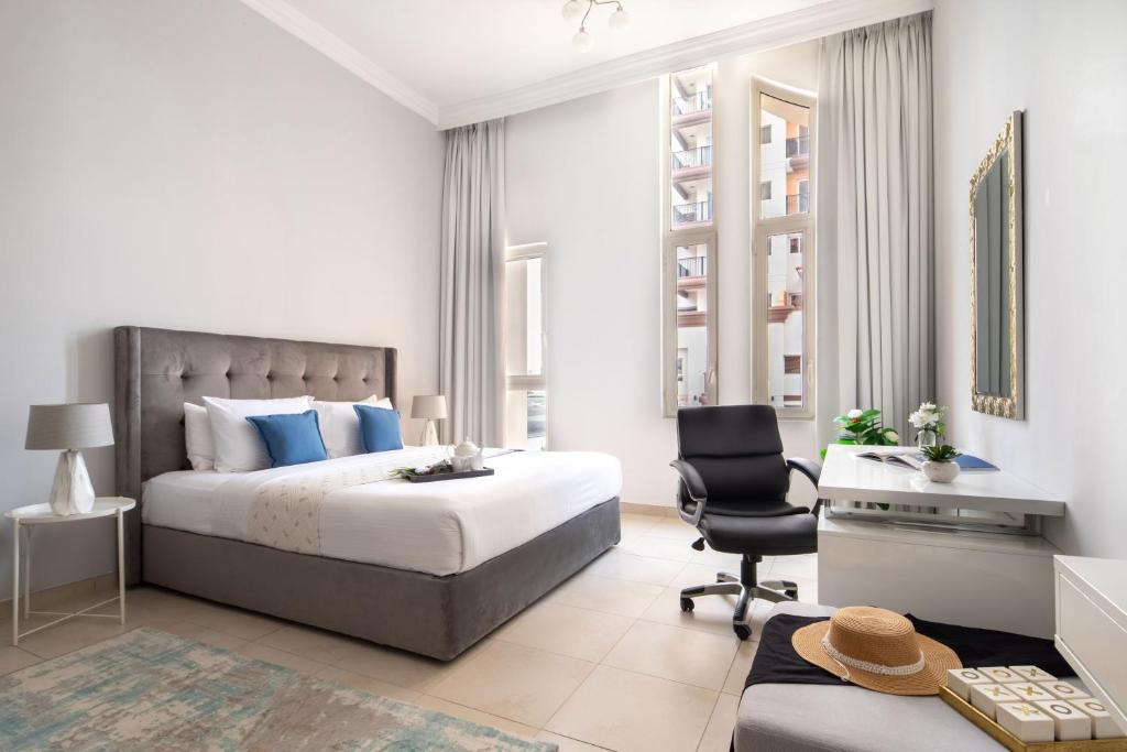 a bedroom with a bed and a desk and a chair at Frank Porter - Canal Residence in Dubai