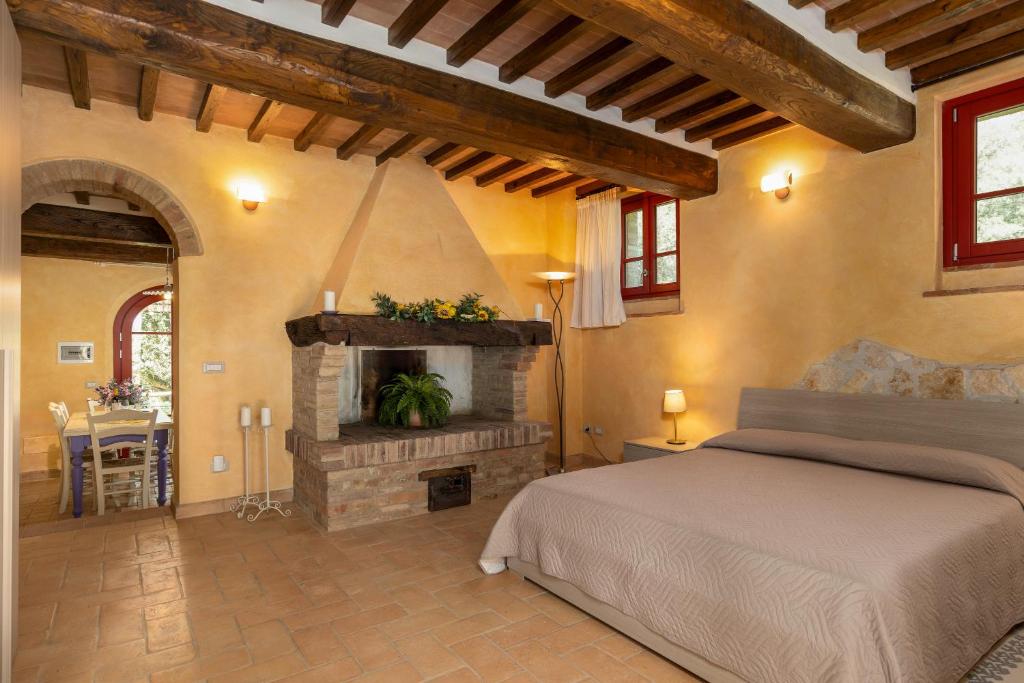 1 dormitorio con 1 cama y chimenea en La Casina di Borgo Mommialla, en Gambassi Terme