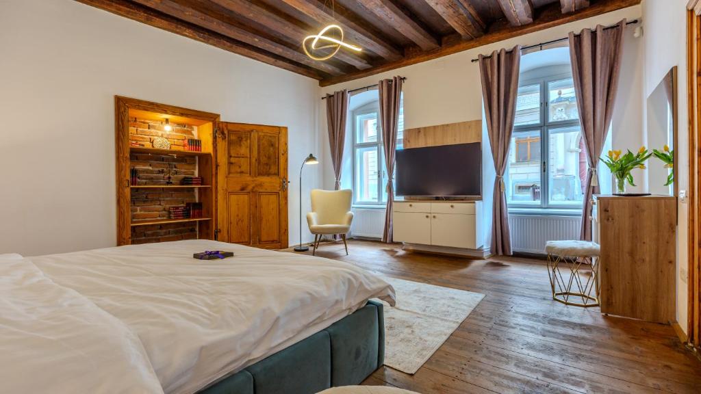 a bedroom with a large bed and a television at Honterus Apartments I by Kronstay in Braşov