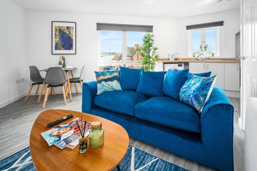 een blauwe bank in een woonkamer met een tafel bij Stylish 2 Bedroom Apartment - Secure Parking - WIFI - Netflix - 27BC in Sleightholme