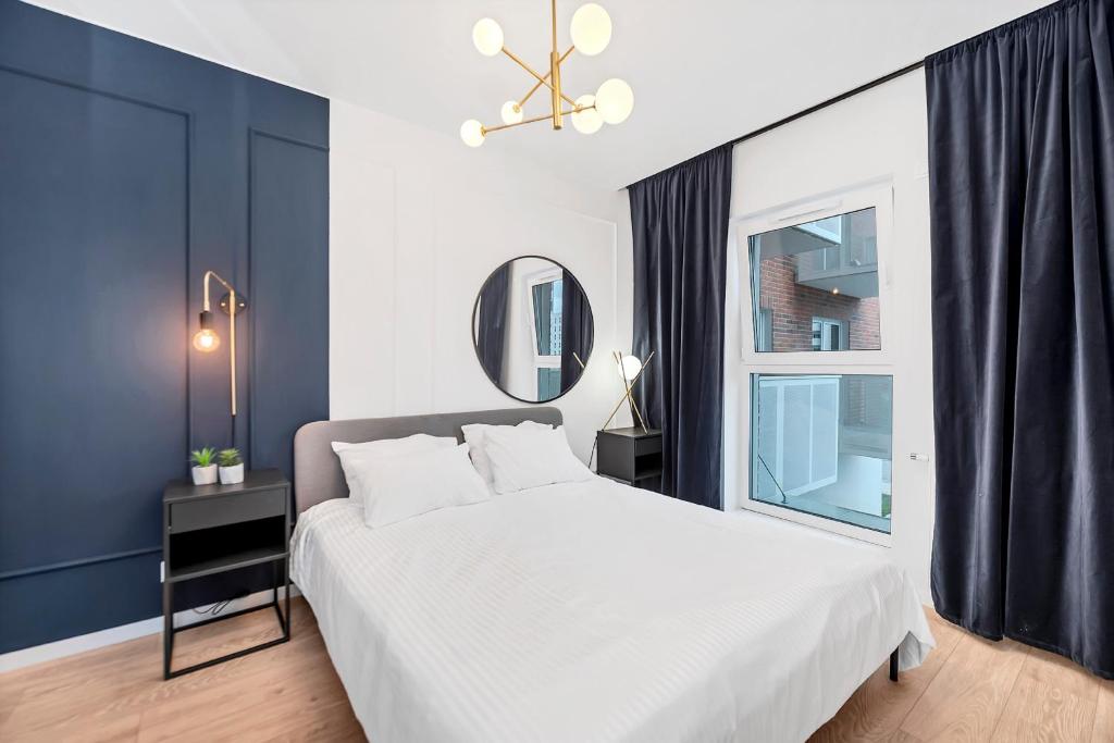 羅茲的住宿－Lumina 2-room apartment with beautiful view Lodz，卧室配有白色的床和窗户。
