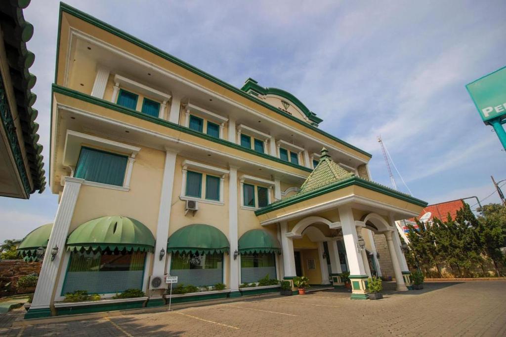 a building with green awnings on the side of it at Permata Hijau in Cirebon