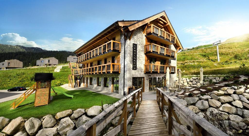 a building with a wooden walkway in front of it at Apartmany Demänovka Jasna in Belá