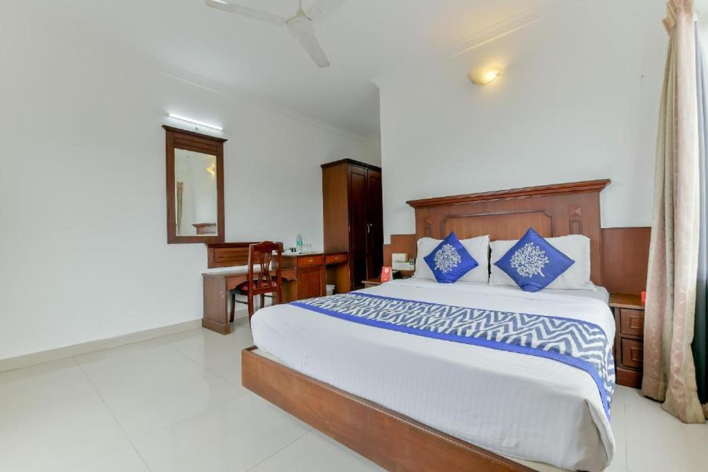 a bedroom with a large bed with blue and white pillows at Centre Point in Cochin