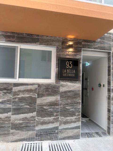 a building with a clock on the wall at La Bella Guesthouse in St. Julianʼs