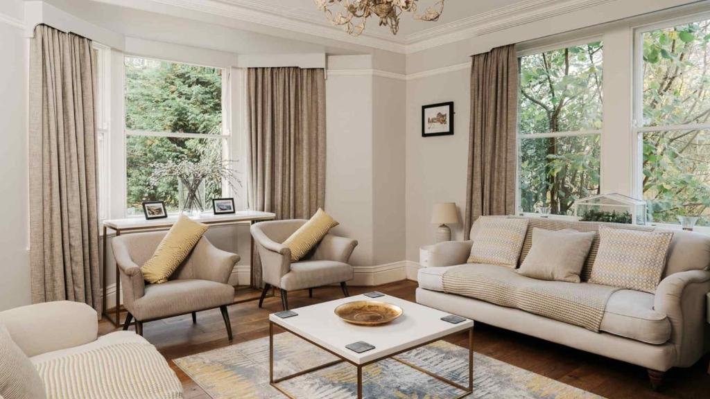- un salon avec un canapé, des chaises et des fenêtres dans l'établissement Dale House, à Buxton