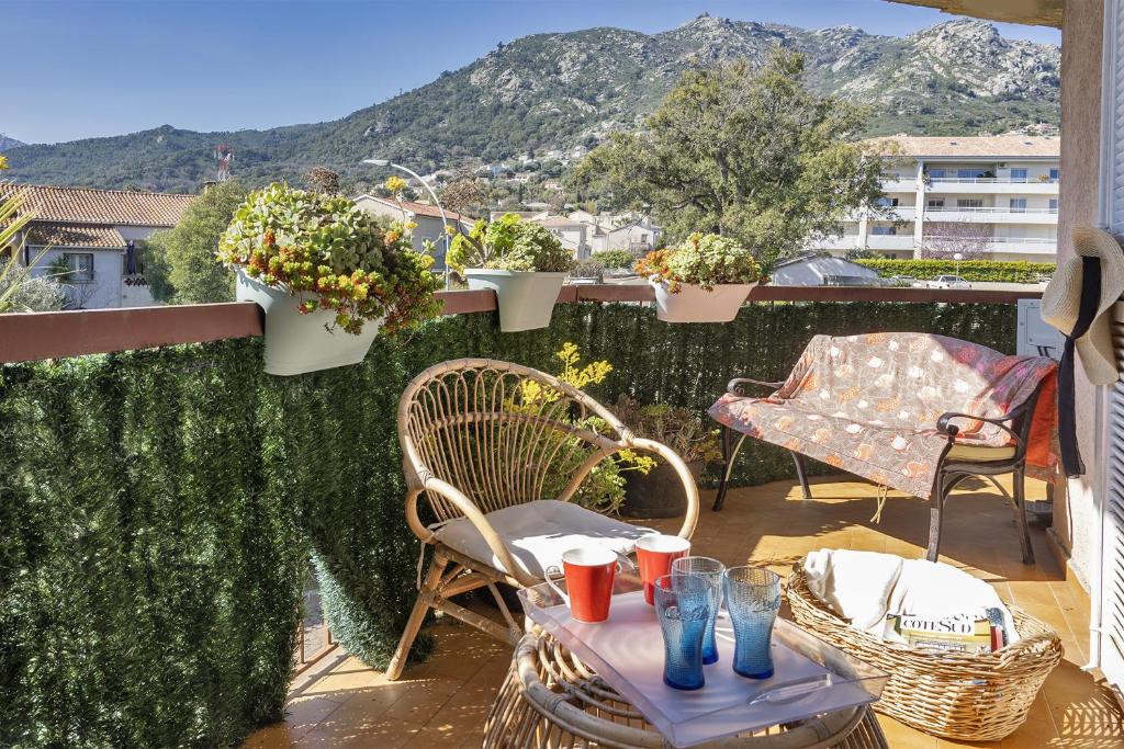 einen Balkon mit einem Tisch, Stühlen und Pflanzen in der Unterkunft Casa Rose in Biguglia