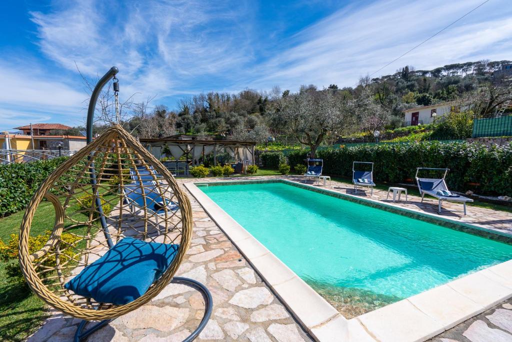 een zwembad met een schommel en stoelen naast een huis bij Il Tiglio-Holiday Home in Massa Lubrense