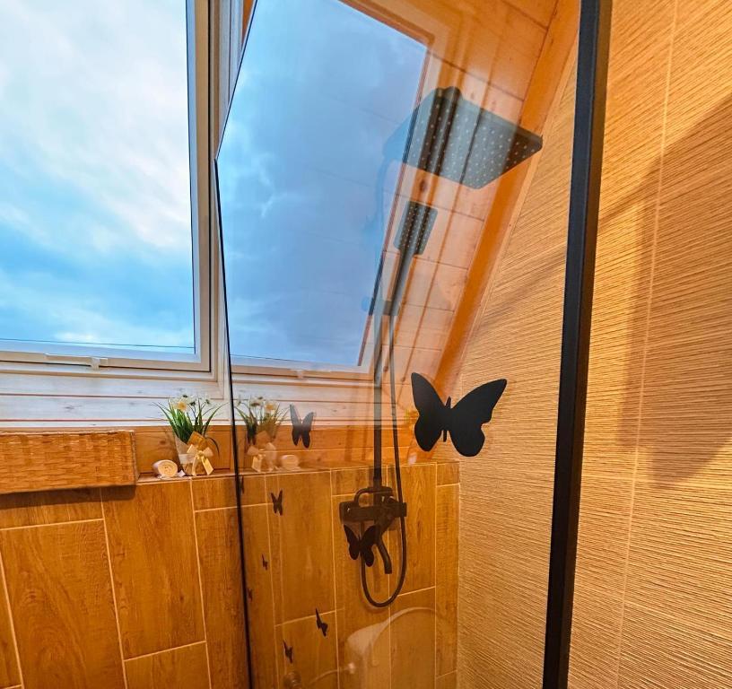 Zimmer mit einem Fenster mit Schmetterlingen an der Wand in der Unterkunft Cabana Ana Barsana in Bîrsana