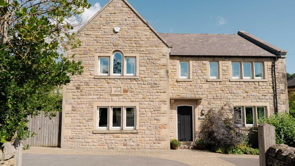 a large brick house with a window at Roslyn in Bakewell