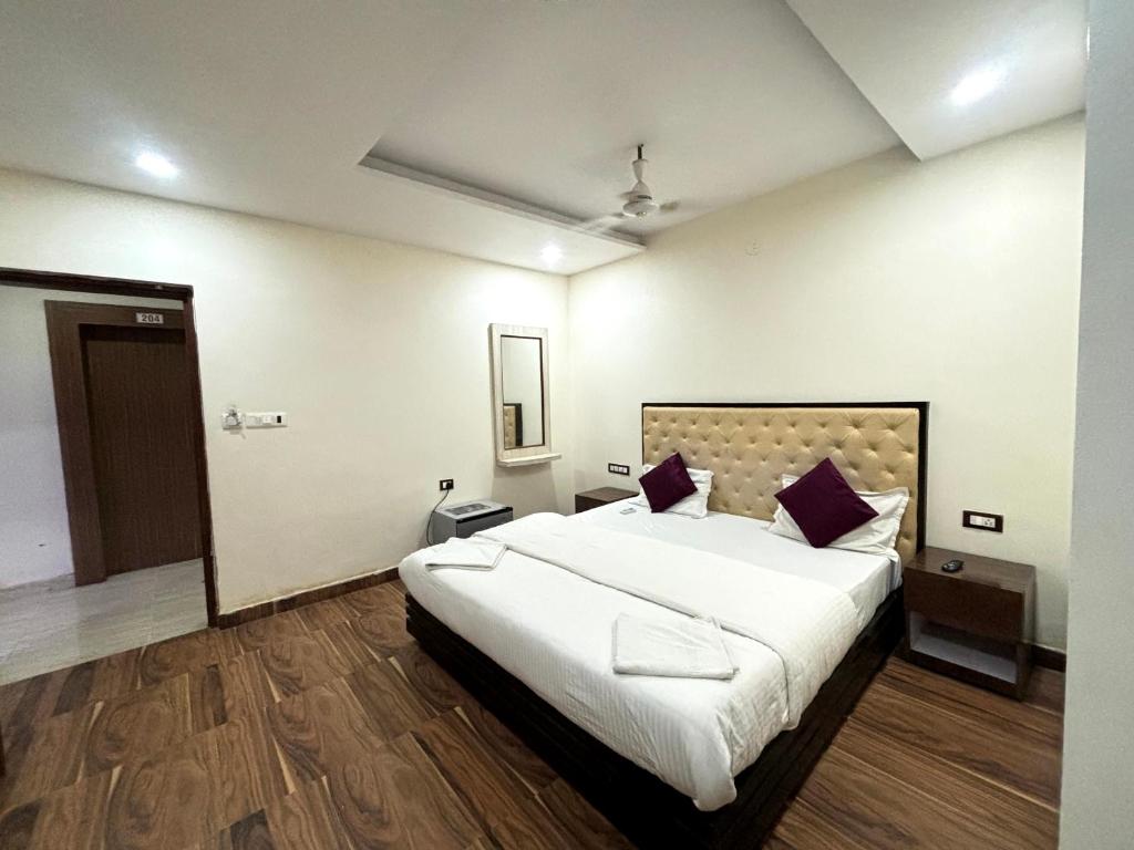 a bedroom with a large white bed with purple pillows at Hotel heaven by sky in Calangute